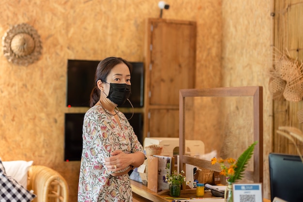 Woman in medical mask checking in at hotel reception