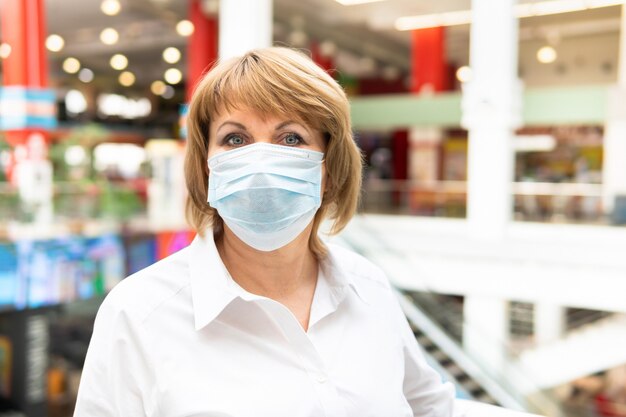 A woman in a medical mask for coronavirus walks through a shopping center in the city. She's afraid of Covid-19