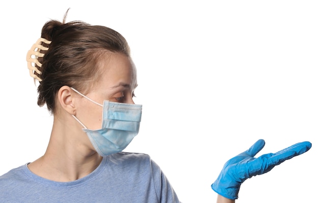 Woman in medical mask and gloves holds palm for copy space isolated on white