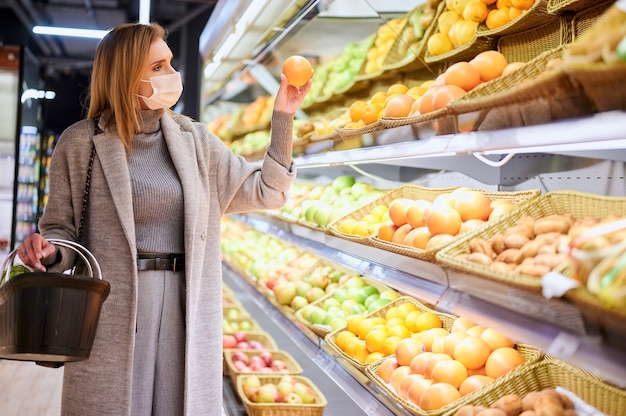 Woman in medical masks is shopping in grocery store during virus pandemic