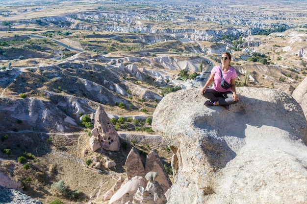 La donna medita vicino all'antica fortezza turca castello di uchisar in cappadocia anatolia turchia