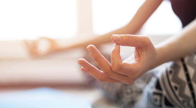 Woman meditating or doing yoga sitting on the mat warm tone