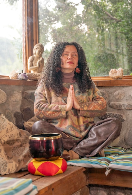 woman meditating indoors with a buddha statue
