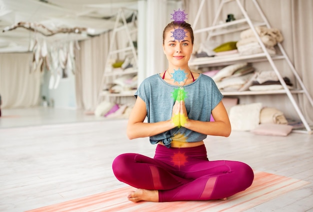 woman meditating in lotus pose at yoga studio