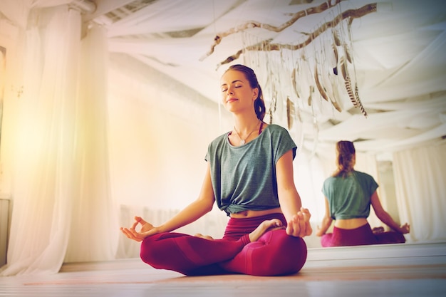 Photo woman meditating in lotus pose at yoga studio