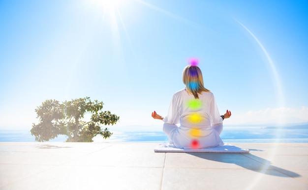 Woman meditating outdoors Concept of seven energy chakras of the human body