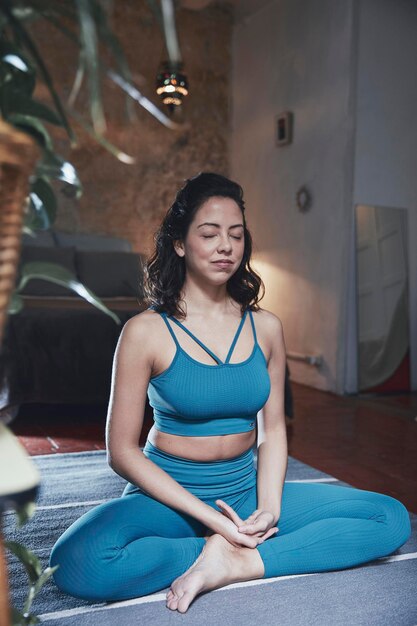 Woman meditating while sitting at home