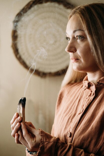 Photo woman meditating with palo santo in studio cleaning space with smoke adult person using burning