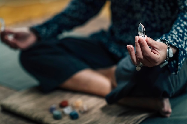 Woman Meditating with Quartz Crystal Chakra Wand in Hand