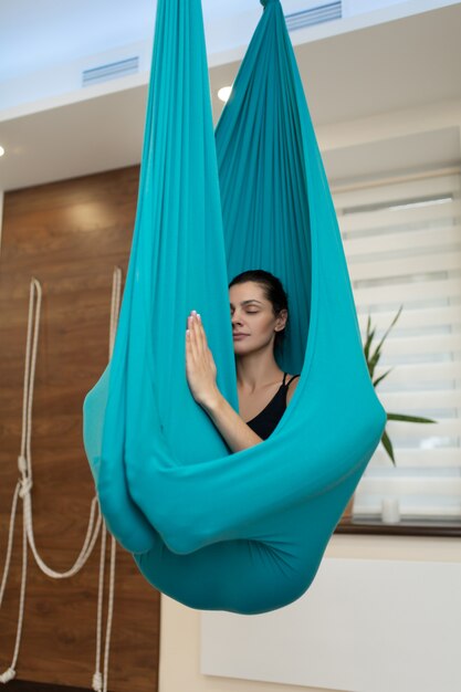 Woman meditation in hammock. fly yoga stretching exercises in gym