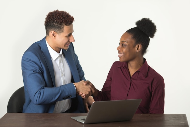 woman in a meeting with a man at the table with a laptop