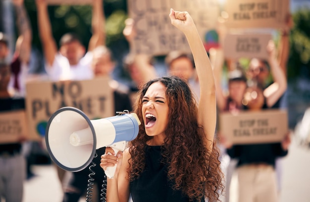 Woman megaphone and shouting with protest crowd change or environment justice in city Bullhorn loudspeaker and female leader for sustainability speech or voice for environment politics on road