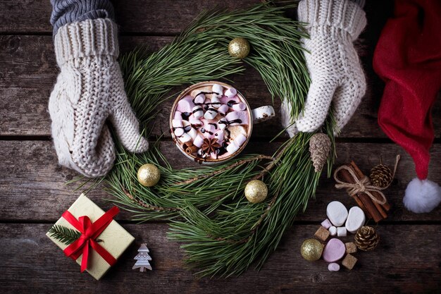 Woman in mittens making Christmas wreath. Selective focus, top view