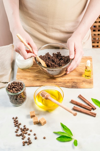 Woman mixing ingredients preparing coffee scrub or mask for skin treatment