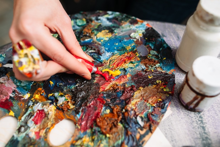 Photo woman mixing paints on palette in art studio