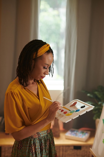 Woman Mixing Paints on Palette