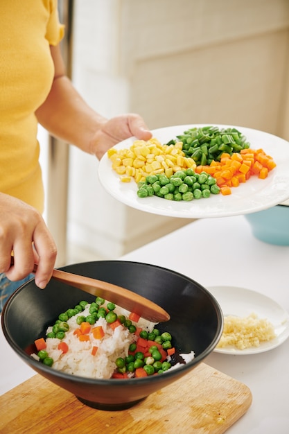 Woman mixing vegetables with rice