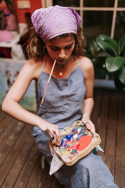 Foto donna che mescola le vernici ad acquerello mentre è seduta sul marciapiede