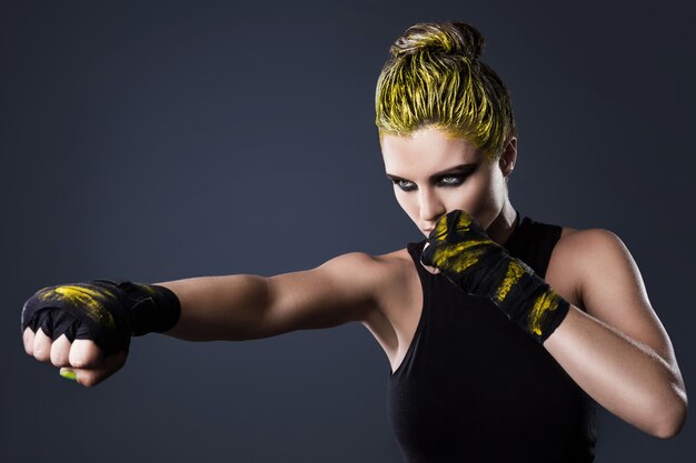 Combattente di mma donna con i capelli gialli