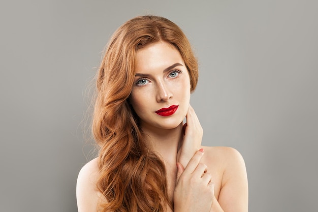 Woman model natural, healthy skin with freckles and long red curly