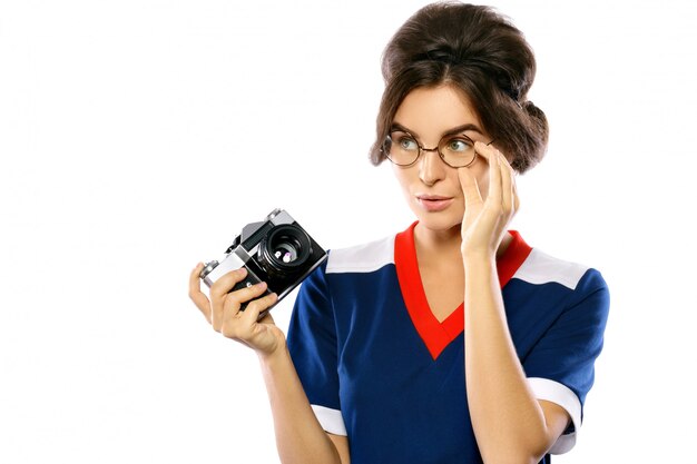 Foto modello di donna in look vintage tenendo la fotocamera retrò nelle sue mani