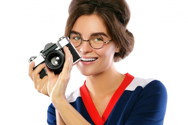 Woman model in vintage look holding retro camera in her hands