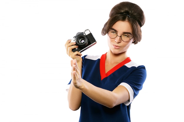 Woman model in vintage look holding retro camera in her hands