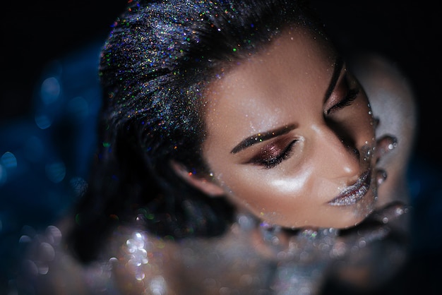 Woman model with make-up and glitter on a naked body