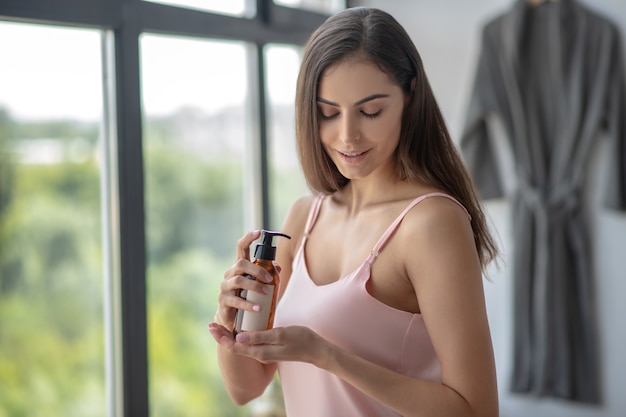 Woman moisturising her skin with a body oil