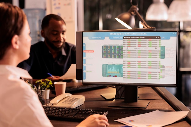 Photo woman monitoring company investment revenue using fund market software in coworking space, stock exchange statistics on computer screen. financial analytics, analysis report