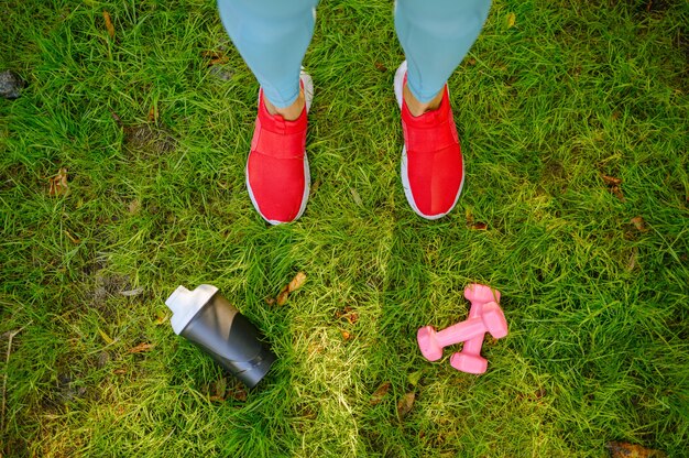 Woman on morning fit training in park, top view on feets