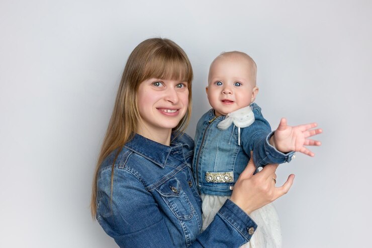 woman mother holding child identically dressed in dress and denim jacket daughter and mother fam