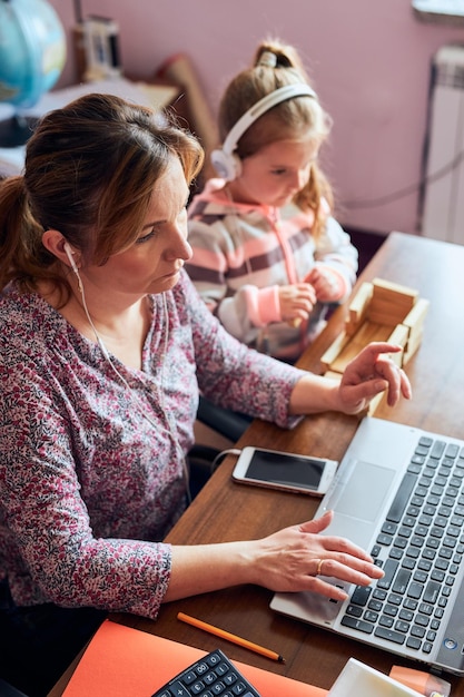 Woman mother working doing her job remotely during video chat call stream online course webinar