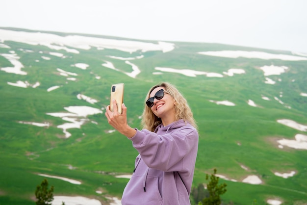 A woman in the mountains with a phone Vacation