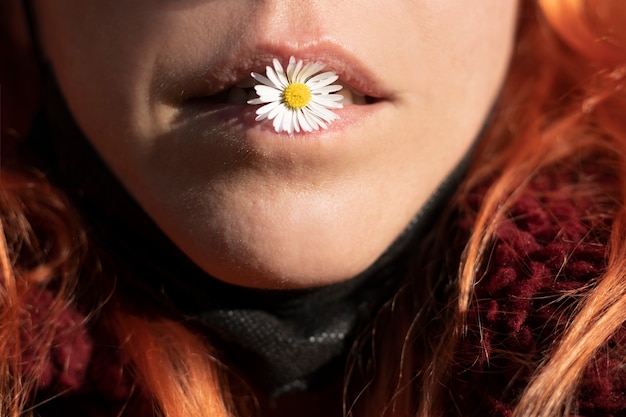 Woman mouth biting a flower