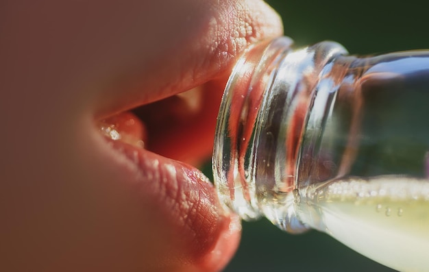 Woman mouth drinking water from bottle closeup drink water sensual lips