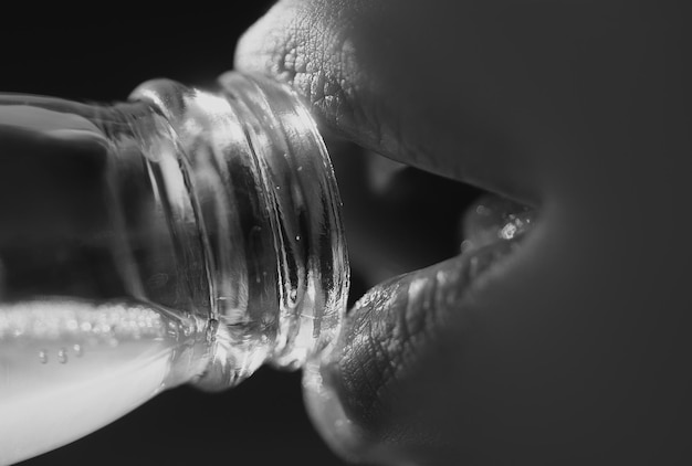 Woman mouth drinking water from bottle Closeup drink water Sensual lips