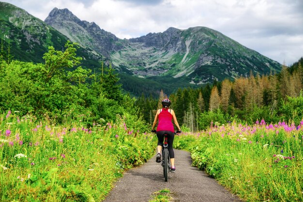 Женщина на велосипеде MTB на дороге в долине Тича в горах Высоких Татр Словакия