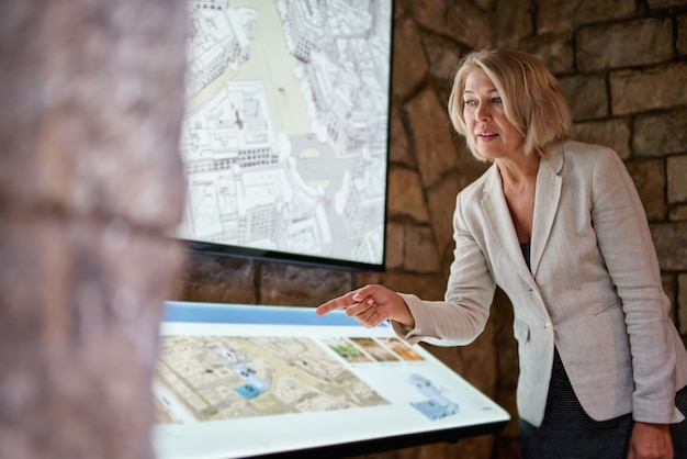 La donna al museo utilizza la guida elettronica del monitor touchscreen, il concetto di vita moderna