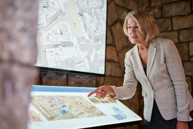 Foto la donna al museo utilizza la guida elettronica del monitor touchscreen