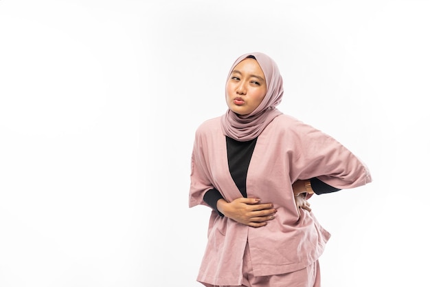 Woman muslim in pain with both hands holding stomach