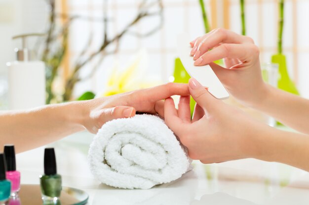 Woman in nail salon receiving manicure