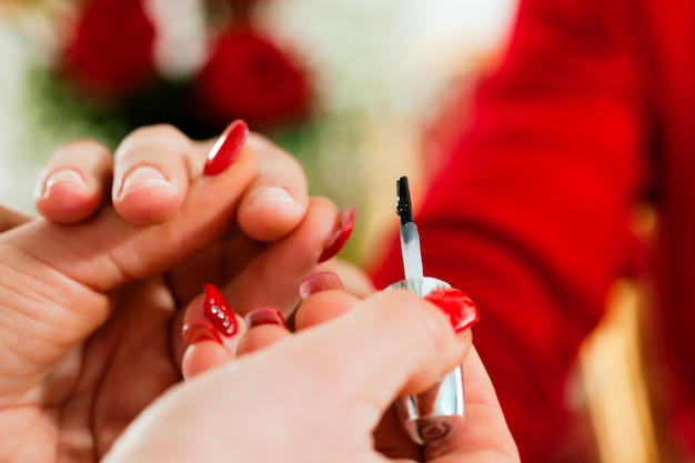 Woman in nail salon receiving manicure