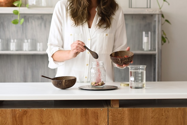 Woman in a natural cosmetics laboratory with flowers and a test tube