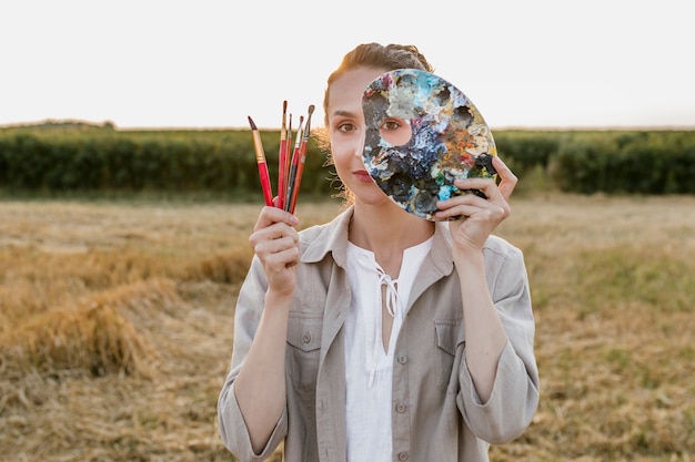 Donna negli elementi della pittura della tenuta della natura