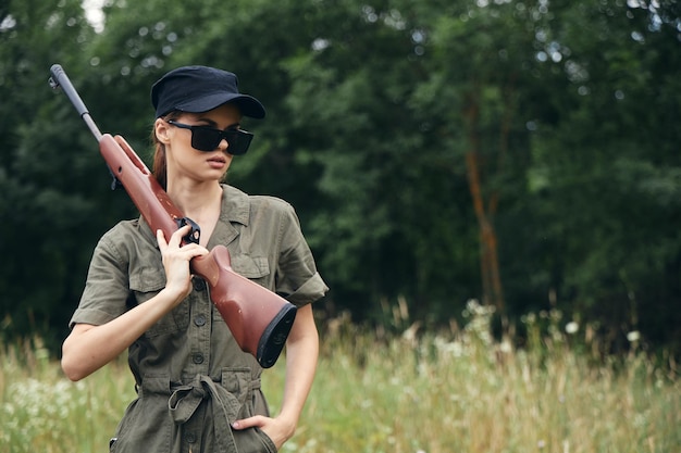 Woman on nature In sunglasses hunting weapons weapons
