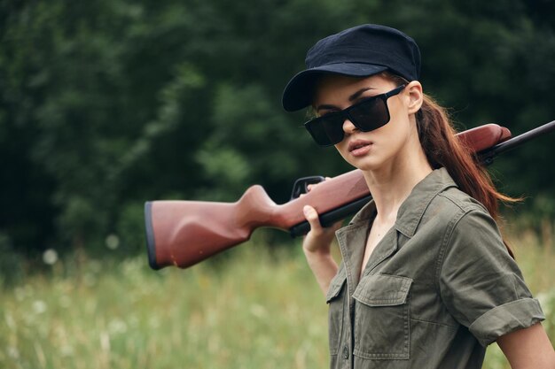 Woman on nature Sunglasses shotgun hunting lifestyle green leaves