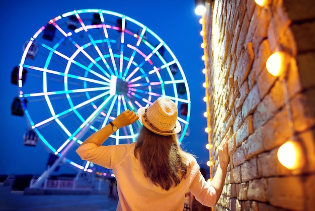 Foto donna vicino alla ruota panoramica di notte