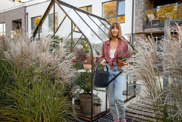 Donna vicino alla serra nel cortile sul retro