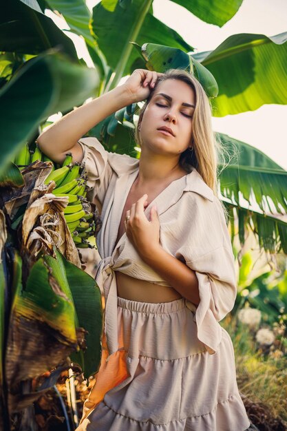 Woman near large green leaf of banana tree on nature in park Tropical plants